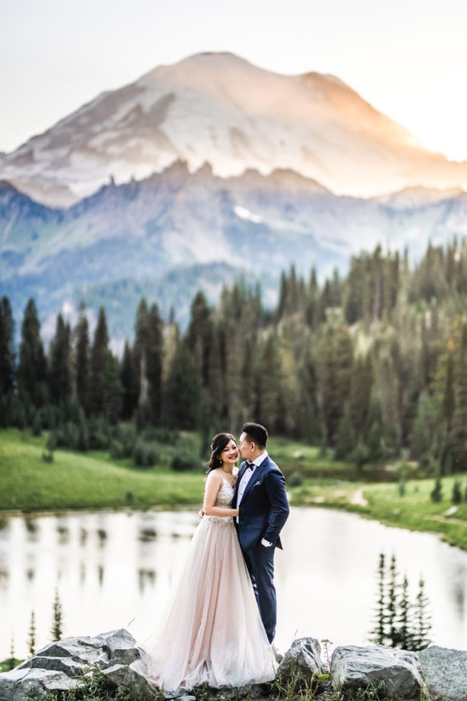 Elopement Photographer, bride and groom stand dressed up before lake, forest and mountain